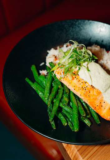 Salmon served with green beans, rice, and sauce at Ray’s Restaurant.