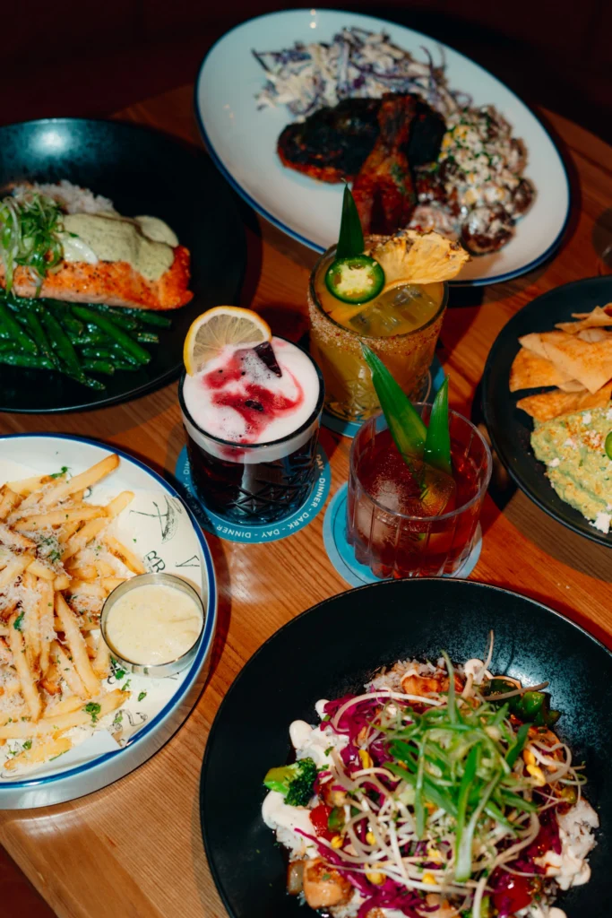Ray's Yaletown table featuring handcrafted cocktails, salmon, fresh guacamole, tortilla chips, fries, and shareable dishes.