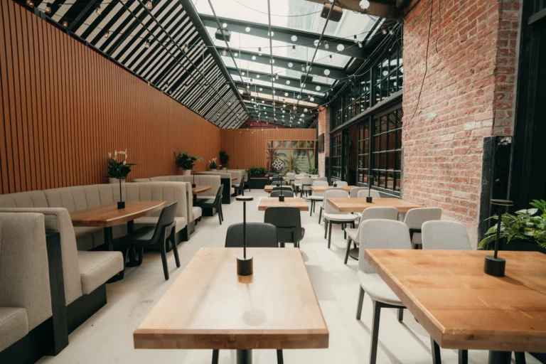 Bright dining room at Ray's in Yaletown featuring wood tables, booth seating, exposed brick walls, and natural light from skylights.