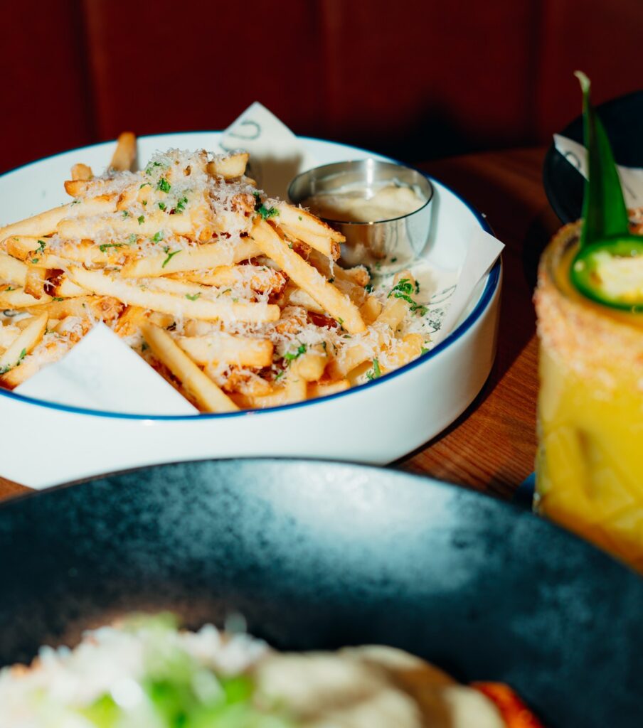 Ray’s Truffle Fries served with dipping sauce and a cocktail during late-night happy hour.
