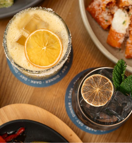 Overhead view of cocktails served with small plates and appetizers at Ray’s Restaurant.